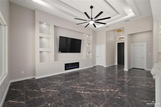9510 N 71st Ln, Mcallen, TX 78573 - unfurnished living room featuring built in features, a ceiling fan, marble tiled flooring, and a glass covered fireplace