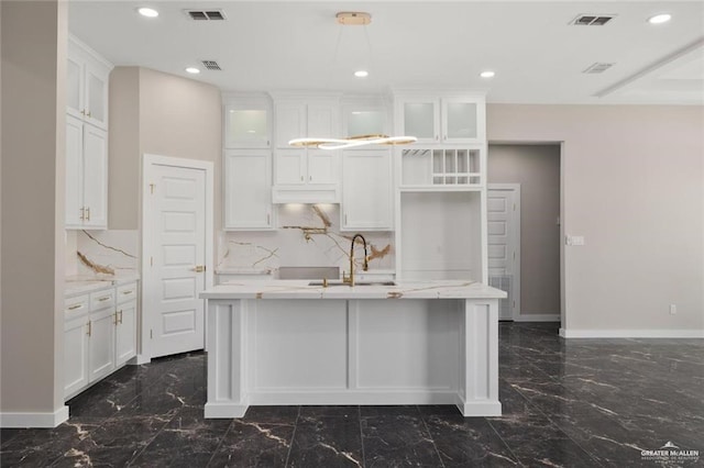 9510 N 71st Ln, Mcallen, TX 78573 - kitchen with dark marble finish floors, a center island with sink, tasteful backsplash, white cabinetry, and recessed lighting
