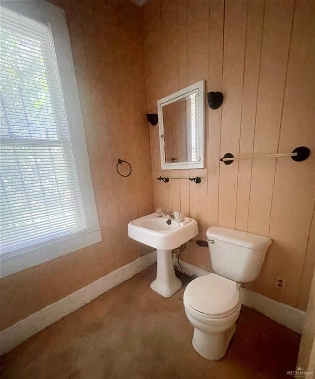 bathroom featuring toilet and wooden walls