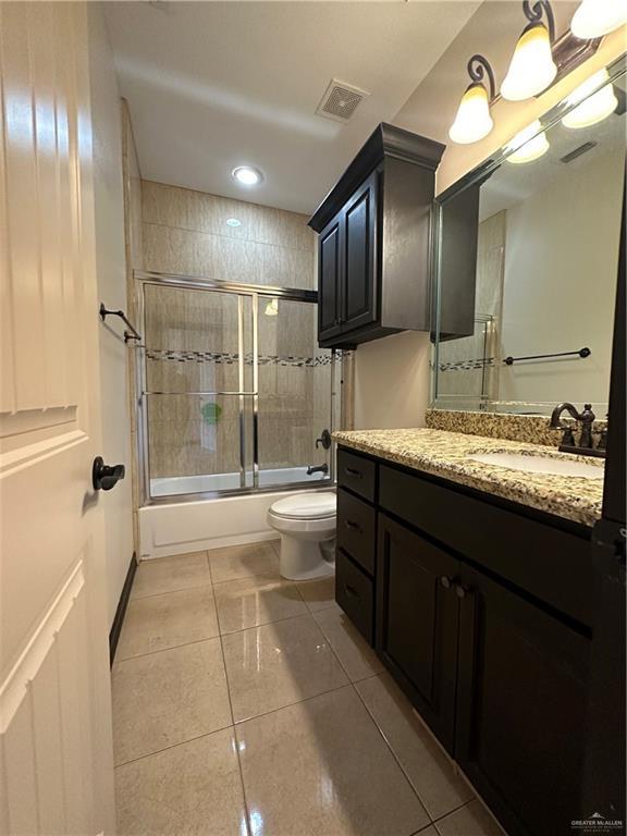 full bathroom with vanity, toilet, combined bath / shower with glass door, and tile patterned floors