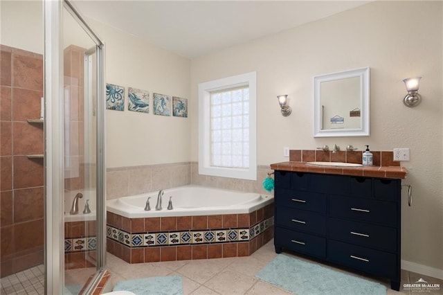 123 Windward Dr, Port Isabel, TX 78578 - full bathroom featuring vanity, a stall shower, a garden tub, and tile patterned flooring