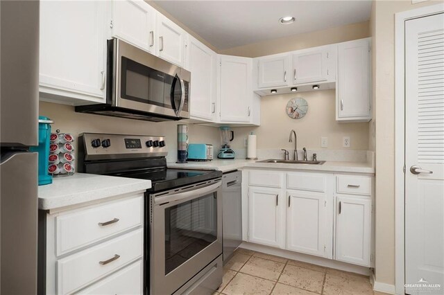 123 Windward Dr, Port Isabel, TX 78578 - kitchen featuring stainless steel appliances, light countertops, white cabinets, recessed lighting, and stone tile flooring