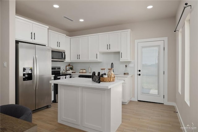 kitchen with white cabinetry, sink, a center island, and appliances with stainless steel finishes