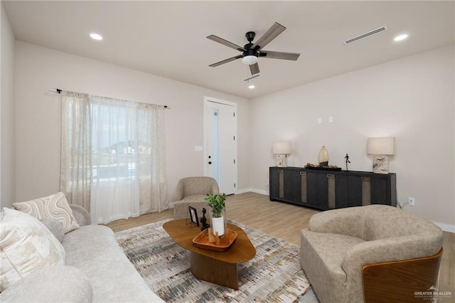 living room with light hardwood / wood-style floors and ceiling fan