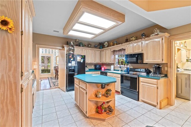 kitchen with light brown cabinets, light tile patterned floors, a kitchen island, and black appliances