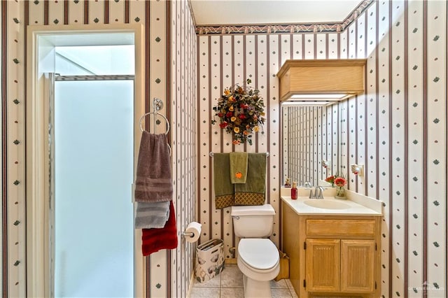 bathroom featuring tile patterned flooring, vanity, toilet, and walk in shower