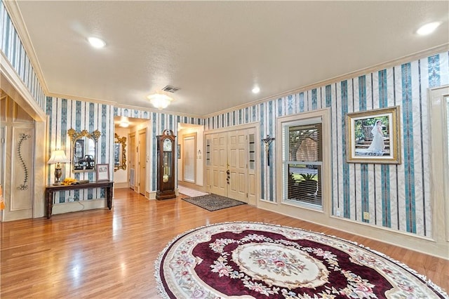 entrance foyer with hardwood / wood-style floors and crown molding