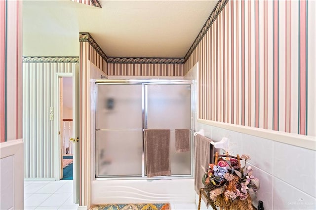 bathroom with tile patterned flooring and combined bath / shower with glass door