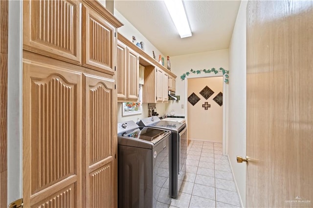 laundry area with cabinets, independent washer and dryer, and light tile patterned floors