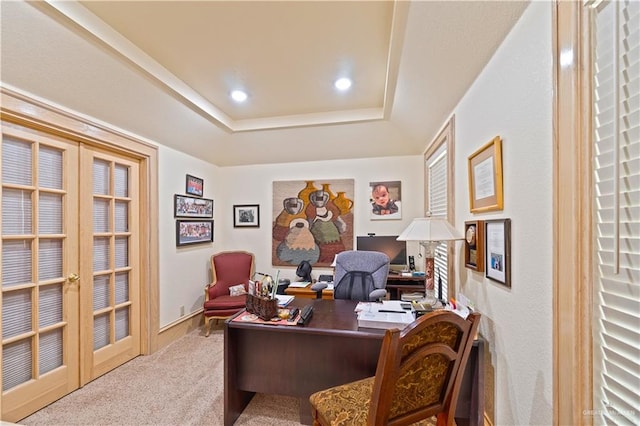 carpeted office with a raised ceiling and french doors