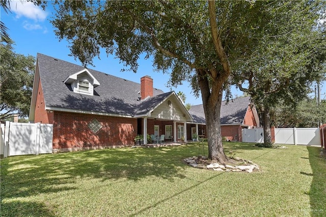 rear view of house featuring a yard