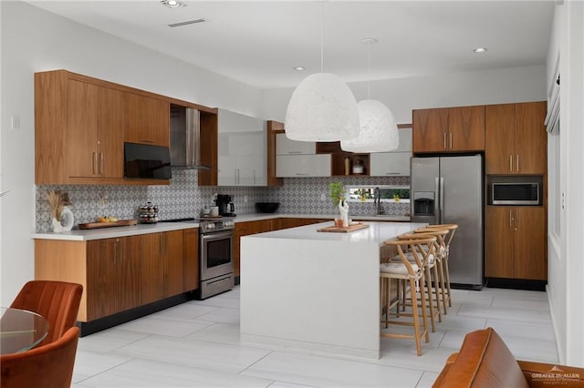 kitchen featuring a breakfast bar area, a center island, stainless steel appliances, tasteful backsplash, and pendant lighting