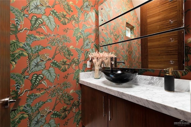 bathroom featuring vanity and wallpapered walls