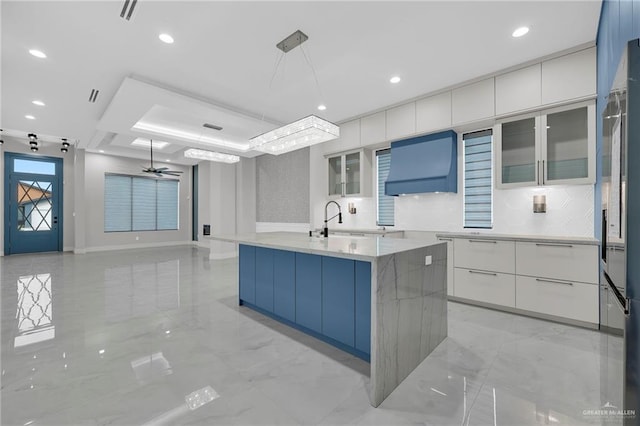 3005 N Alyna Ave, Edinburg, TX 78541 - kitchen featuring modern cabinets, ventilation hood, white cabinetry, glass insert cabinets, and decorative light fixtures
