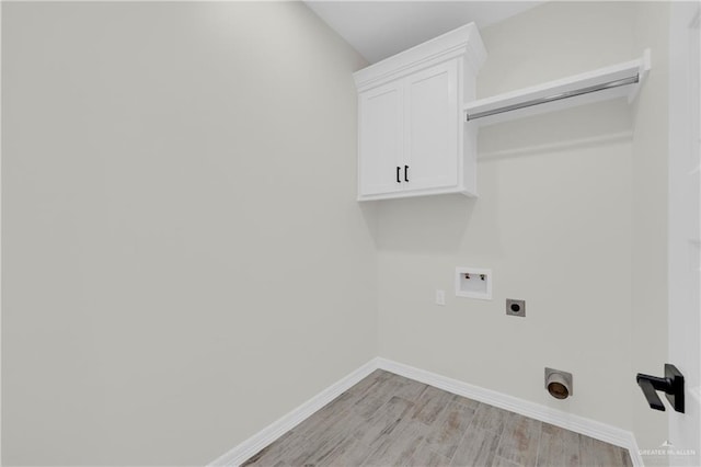 laundry area featuring electric dryer hookup, light wood-type flooring, washer hookup, cabinet space, and baseboards