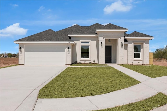 prairie-style house with a front lawn, roof with shingles, stucco siding, a garage, and driveway