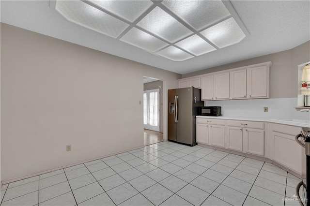 kitchen with white cabinetry, appliances with stainless steel finishes, sink, and light tile patterned floors