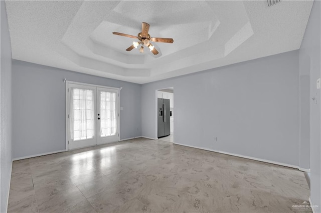 unfurnished room with french doors, ceiling fan, and a tray ceiling