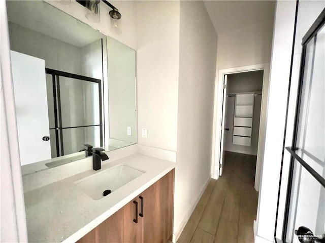 bathroom with vanity, hardwood / wood-style floors, and an enclosed shower