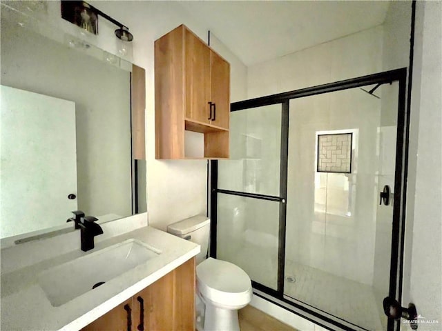 bathroom featuring vanity, an enclosed shower, and toilet