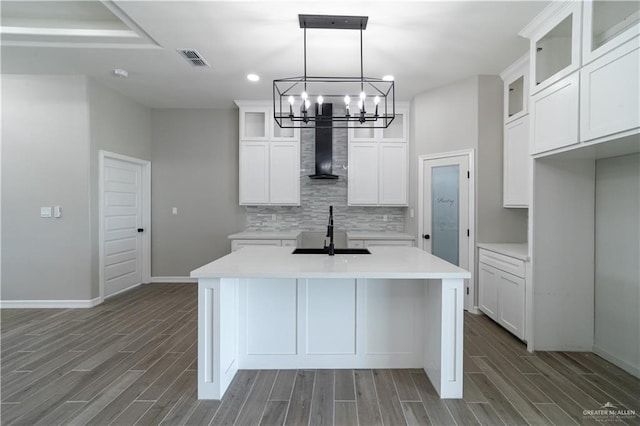 kitchen with exhaust hood, a sink, wood finished floors, a chandelier, and recessed lighting