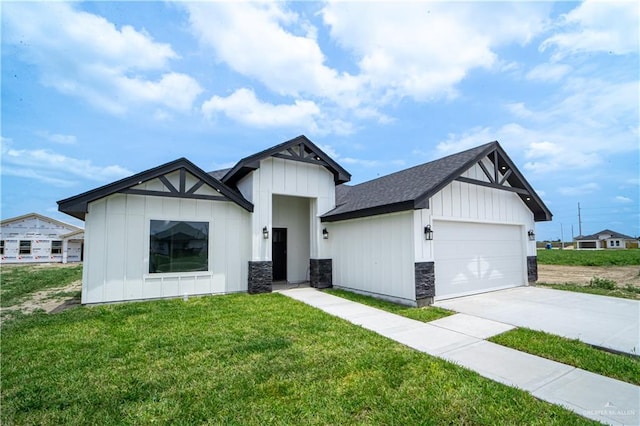 modern farmhouse featuring board and batten siding, a front lawn, an attached garage, concrete driveway, and stone siding
