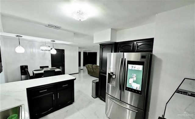 kitchen with stainless steel fridge, a chandelier, and decorative light fixtures