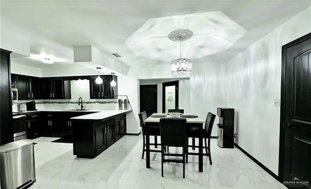 kitchen featuring a kitchen island, a kitchen bar, hanging light fixtures, and appliances with stainless steel finishes