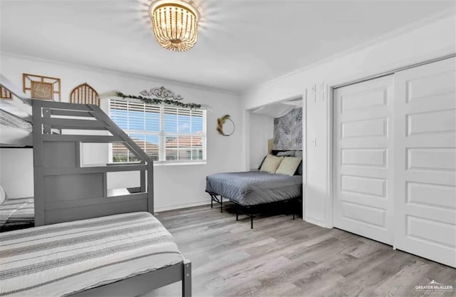 bedroom with wood-type flooring, a closet, and crown molding