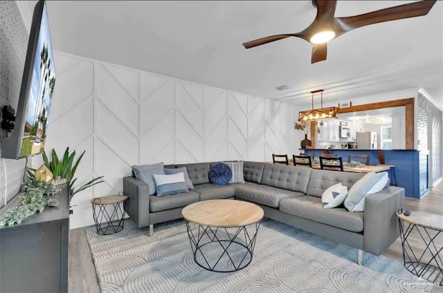 living room featuring light wood-type flooring and ceiling fan