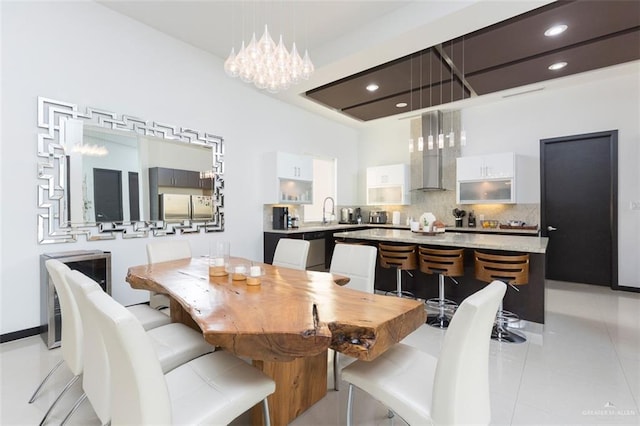 dining space featuring light tile patterned floors, an inviting chandelier, and sink