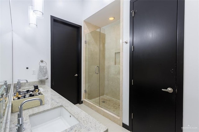 bathroom featuring a shower with door and vanity