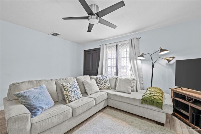 living room featuring ceiling fan and hardwood / wood-style flooring