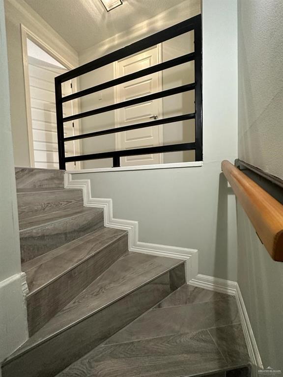 staircase featuring a textured ceiling