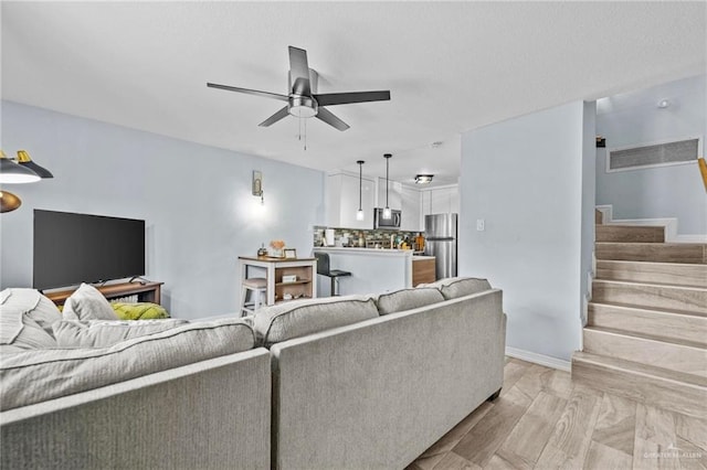 living room featuring light hardwood / wood-style flooring and ceiling fan