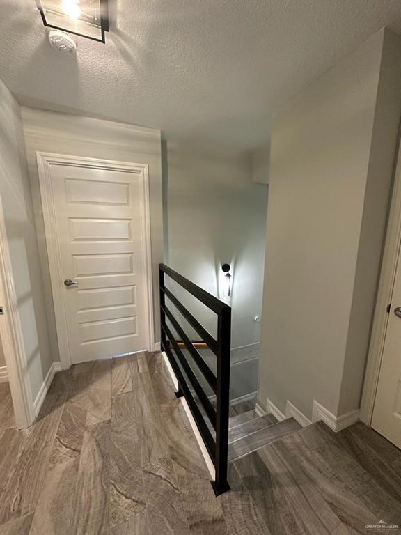 stairway featuring a textured ceiling