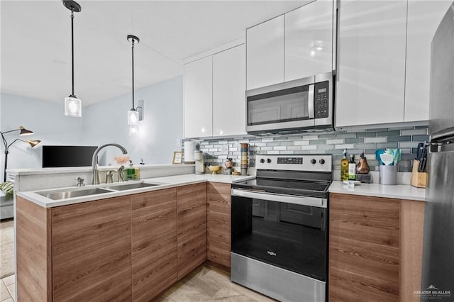 kitchen featuring white cabinets, sink, appliances with stainless steel finishes, tasteful backsplash, and decorative light fixtures