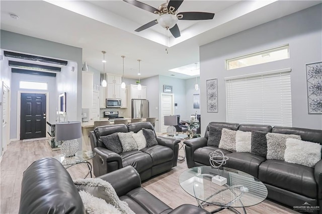 living room with ceiling fan and light hardwood / wood-style flooring