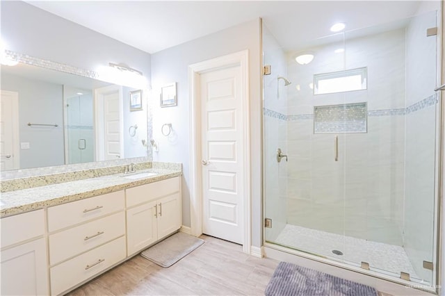 bathroom featuring vanity, wood-type flooring, and an enclosed shower