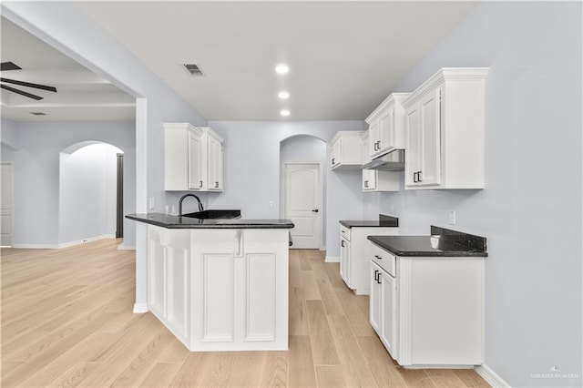 kitchen featuring ceiling fan, kitchen peninsula, light hardwood / wood-style floors, and white cabinets