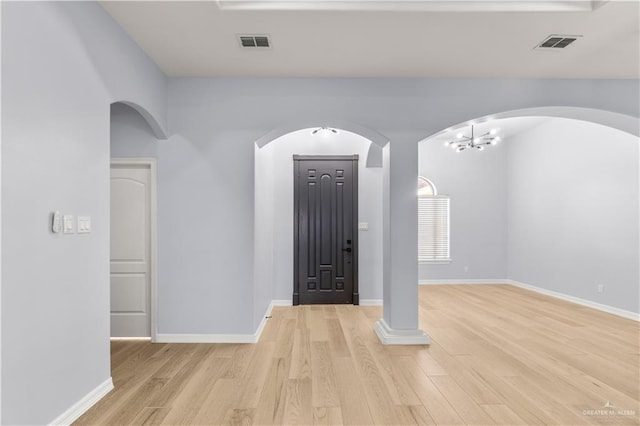 entrance foyer featuring an inviting chandelier and light hardwood / wood-style flooring