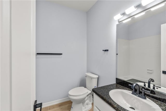 bathroom with hardwood / wood-style flooring, vanity, toilet, and a shower