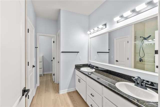 bathroom featuring hardwood / wood-style flooring, vanity, and a shower with shower door