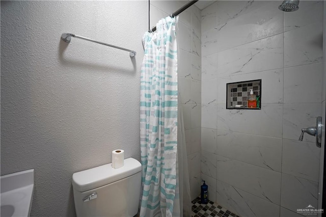 bathroom featuring a shower with curtain and toilet