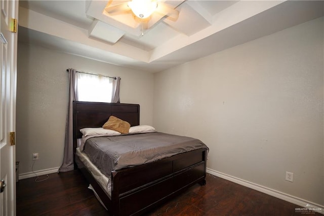 bedroom featuring ceiling fan, dark wood-type flooring, and a tray ceiling