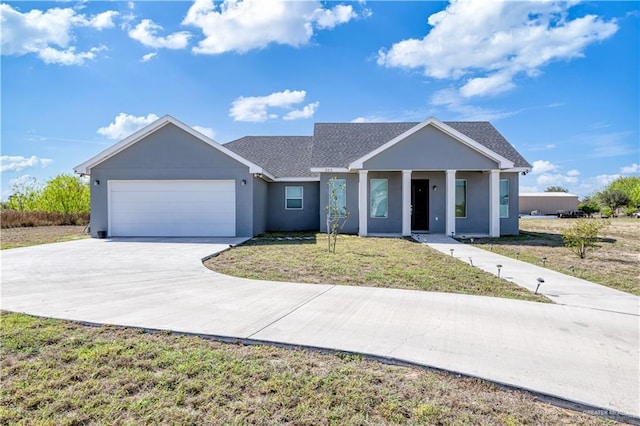 view of front of house with a front lawn, concrete driveway, roof with shingles, stucco siding, and an attached garage