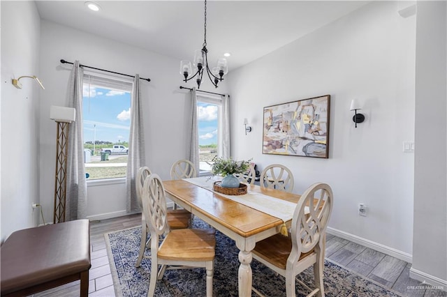 dining room with recessed lighting, light wood-type flooring, baseboards, and a notable chandelier