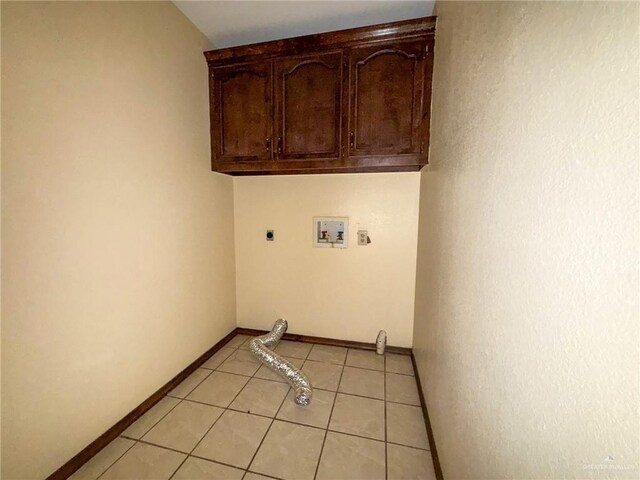 clothes washing area featuring cabinets, hookup for an electric dryer, hookup for a washing machine, and light tile patterned floors