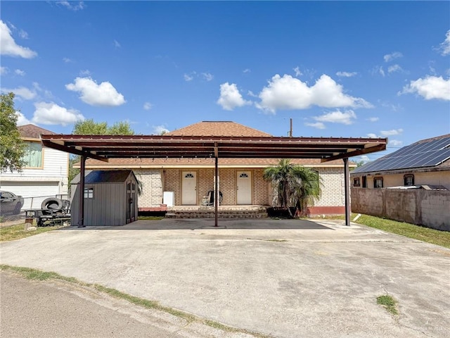 view of front of house with a carport and a storage unit