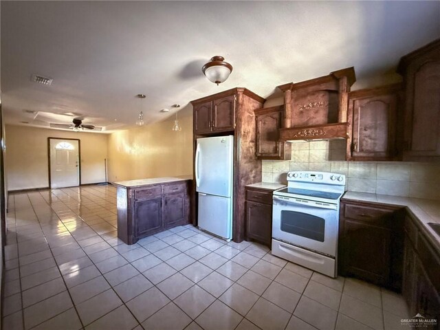 kitchen featuring light tile patterned floors, white appliances, backsplash, custom range hood, and kitchen peninsula